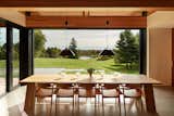 Every room in the home enjoys views of the landscape—including the dining area. The natural material palette of the interior emphasizes this connection between inside and out.  Photo 14 of 17 in This Vacation Home in Rural Ontario Sets a New Standard for Prefab Architecture