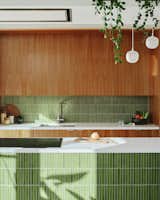 The backsplash is made from the same green kit kat tiles that clad the island. The worktops are Silestone, a solid surface by Cosentino, and cost $X,XXXX. To save on overhead and profit costs—which are usually calculated by the contractor at 10% to 15%—the clients purchased tapware, kitchen appliances, and lighting themselves. The pendants in the kitchen are Muuto Rime Pendants, which retail for $XXXX for the small and $XXXX for the medium.