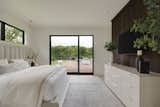 The family bedrooms are arranged in two wings on the main floor, with three children’s bedrooms on one side of the great room and the primary on the other. Operable glass doors in the primary bedroom open out to a large terrace for entertaining.