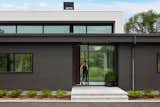 The entrance hall is sandwiched between two enormous glazed panels, offering immediate views through the home to embrace views of the lush wetlands that surround the property. The clerestory windows that wrap around the top of the main living area peek over the top of the darker form, offering a hint of what’s to come.