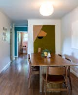 The bold use of color in the kitchen echoes the bright palette found in other rooms in the home, glimpses of which can be seen from the dining area.