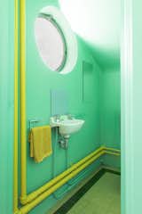 <span style="font-family: Theinhardt, -apple-system, BlinkMacSystemFont, &quot;Segoe UI&quot;, Roboto, Oxygen-Sans, Ubuntu, Cantarell, &quot;Helvetica Neue&quot;, sans-serif;">The downstairs bathroom is mostly original—including the tiles on the floor and the heating pipes. Rather than change the fixtures and fittings, the couple cleverly updated the bathroom using color.</span>