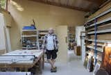Artist and homeowner Simon Quinn in his studio space. Clerestory windows run along one wall, allowing natural light into the studio without compromising storage needs.