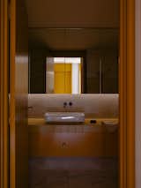 The bathrooms feature timber joinery and aged brass hardware that is inspired by the golden veining of the marble.