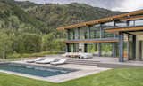 The home features resort-style amenities, including a pool surrounded by loungers, two fire pits, and an outdoor entertaining area.