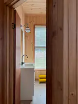 Like the rest of the home, the bathroom is clad in timber and features linoleum flooring, a natural material made using linseed oil. This approach negates the need for costly tiles. “Linoleum is a beautiful, long-lasting material,” says Lev. “You often see it used in pre-schools and hospitals, but rarely in residential projects. It’s puzzling to me as it’s readily available, affordable, and natural.”