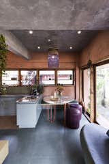 The dining table was custom-made from scrap, with salvaged stone slabs for the surface and bent TMT bars forming the legs. NO Architects drew up the design and it was crafted by a local artisan. The sofa and built-in bench were also crafted from leftover materials, resulting in the playfully mismatched upholstery.