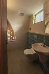 The bathroom on the upper floor features an open shower and is ventilated naturally via the perforations in the jaali. The tiles were donated by a local sponsor.