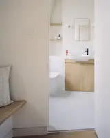 The new bathroom—which was much needed in a family of four with two teenagers—is tucked away behind a curved partition wall and echoes the material palette used throughout the extension.