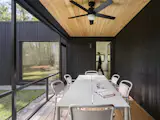 A screened porch is located at the junction of the home’s two circulation axes. Nakamoto Forestry Gendai Linseed Black yakisugi cladding wraps the interior walls while a natural wood ceiling adds warmth overhead. "In the summertime the screened porch is where we love to have family dinners and unwind in the evenings," says homeowner, Joe.