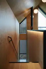 Even the stairs to the bunk loft were milled from mass plywood, with a curved nosing that softens the otherwise pared-back detailing.