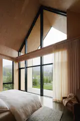 Breaking the glazing into smaller sections allows the bedroom to feel open to the landscape without losing its sense of enclosure.