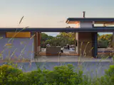 Sliding glass doors on both sides of the 2,820-square-foot, single-level home dissolve the boundary between inside and out, opening the living spaces to the surrounding landscape.