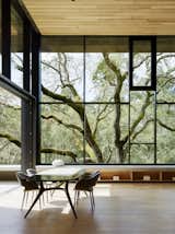 With an elegant feel that seemingly echoes the branches of the trees outside, this dining room set up in Orinda, California, is perfect for nature lovers seeking a simple, timeless aesthetic. Faulkner Architects built an open-concept layout for the homeowners under the shade of a Valley Oak. Ebony elements in the window casings, chairs, and table legs create an elegant contrast with the light wood floors and ceilings. They also incorporated a 12-foot-wide sliding pocket wall that opens the dining room to the terrace, adding versatility.