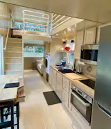 ESCAPEROO ONE - Kitchen has custom wood cabinetry, butcher block top, deep stainless sink and designer faucet, long shelving, tall refrigerator/freezer and electric oven + induction cook top + microwave. Washer / dryer combo. Sealed, sustainably grown Birch interior. 