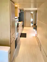 ESCAPEROO ONE - Hallway to kitchen, washer/dryer combo, storage cabinets and great lighting.
