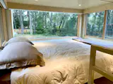 ESCAPEROO ONE - Loft area fits a queen size bed on a wooden platform with block-out curtains all around and operable windows with screens.