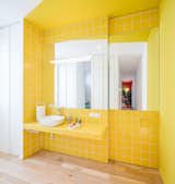 Spanish firm Gon Architects and designer Ana Torres renovated this 69-foot-long Madrid flat to include a yellow-tiled bathroom, salmon-hued bedroom reading nook, and bright-blue kitchen stand. The home’s colorful corners are tied together by white passages and subtle wood floors.&nbsp;