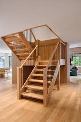 The existing staircase was re-finished and new handrails were added to bring it up to current codes and style.  The new white oak fluted wood paneling gives a nod to the 1970's while making the space feel fresh and current.  This central column is the main feature in the space that gives cohesion to the open floor plan that circulates around it.