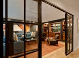 An existing theater room with stadium seating was demolished to create the swanky lounge space, separated by the rest of the first floor by new steel doors. 