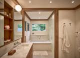 New primary bathroom with spa bath and frosted glass toilet room.  