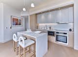 Kitchens are appointed with chef-level Fisher & Paykel and Beko appliances, quartz countertops, and full-height backsplashes