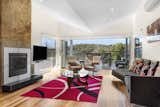 Living room with feature stone fireplace and views over bushland
