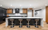 Book-matched walnut cabinetry with integrated handles.. Waterfall quartz counters put the final touch on this stunning look!