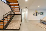 Staircase, Concrete Tread, Wood Tread, Metal Tread, and Metal Railing Preserved but re-built stairway with atrium-style space below  Photo 15 of 25 in The Ron Molen Resto' by D3CADE Homes Co.