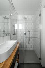 Bath Room, Wood Counter, Enclosed Shower, Wall Lighting, Ceramic Tile Wall, and Vessel Sink Shower   Photo 1 of 9 in Worker's dormitories by Dina Weinberger Finkelstein
