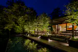 Exterior View of outdoor multi-level entertaining decks and container pool at night 