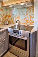 The kitchen accommodates a full size induction range in a fully functional compact layout.