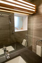 Light filters into the bathroom via the frosted kitchen backsplash from the window beyond.