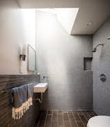 Small bathroom tucked away behind the kitchen stove wall with a skylight.