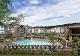 Design distinction extends outside, where open-air amenities include a pool, pool house, landscaped terrace with a fire pit, sun loungers, televisions, tot lot, a walking path, and a fitness area for invigorating, fresh-air workouts. 
