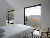 The master bedroom is tucked at one end of the house’s long plan, and it shares valley views with the living room. 