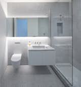 Small, penny-shaped Carrara marble tiles add texture to the master and guest bathrooms, which share a similar template.