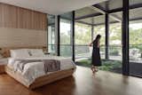 The master bedroom on the second storey has privacy buffer with the placement of the generous patio and tree void upfront. The custom bed frame designed by Stacey Leong Interiors continues the architecture's linear language.