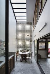 A new semi-outdoor space is created by enclosing the former house’s foyer with a skylight and concrete breeze-block screen. It functions excellently as a wet kitchen, with cooking smells filtering through the screen. 