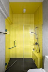 Singapore-based iterior designer Ponnie Tan of EightyTwo infused a local apartment with a striking scheme that borrows from&nbsp;Wes Anderson’s&nbsp;oeuvre. The principal bathroom features a sunflower yellow–tiled shower. In the the living room, canary-yellow walls match a sofa of the same color.&nbsp;
