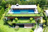 A swimming pool at the top floor of the Sky Pool House by Guz Architects in Singapore has a glass cut-out in its floor to bring the calm feeling of water overhead to the lower levels. This accompanies plenty of roof and ground gardens to immerse the occupants as much as possible within nature.