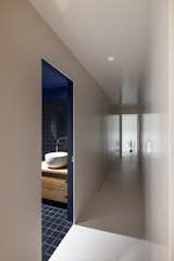 The all-white home presents a surprise in the powder room with dark tiles from Complementto and navy blue sanded grout from Grout360.