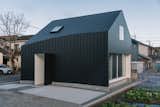 Exterior, A-Frame RoofLine, House Building Type, Metal Siding Material, and Metal Roof Material "The curved surface of the west facade, with its ribs, visualises a gentle rhythm and softens the black building," says Sudo.   Photo 1 of 15 in In Japan, a Straight-Ahead Gable Home Takes an Unexpected Turn