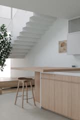 The dining room is fronted by the dry kitchen counter, which enjoys a view of the tree at the planter and light from the skylight above. 