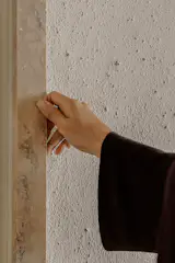 “It extends roughly 120 square metres of the apartment. With its thickness, the material has a breathability to it, which absorbs and subtly modulates the humidity of the interior air volume, and creates a comfortable air quality in the tropical capital, says  Suphasidh on the lime and earth surfaces; the handles are in Rome travertine. 
