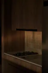 The kitchen countertops use Dekton Marmorino, which can also tolerate high heat and is less susceptible to food stains; handcrafted tiles enhance the apartment's warm aesthetic. 