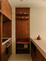 At the open kitchen, solid birch plywood cabinetry and wall panelling add some tones and subtle patterns; the material is also evocative of the mid-modern century era. 