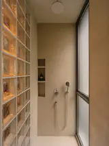 The master bathroom's shower stall now has simple tiled surfaces and interesting play of light due to the screen of glass blocks. 