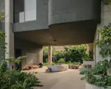 The living room is naturally ventilated and edged by greenery. "The rooms are oriented to look towards the forest," says architect Tay Yew. 
