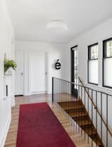 Existing hallway with new steel stair railing, updated doors and windows, fresh paint and wood floor refresh.